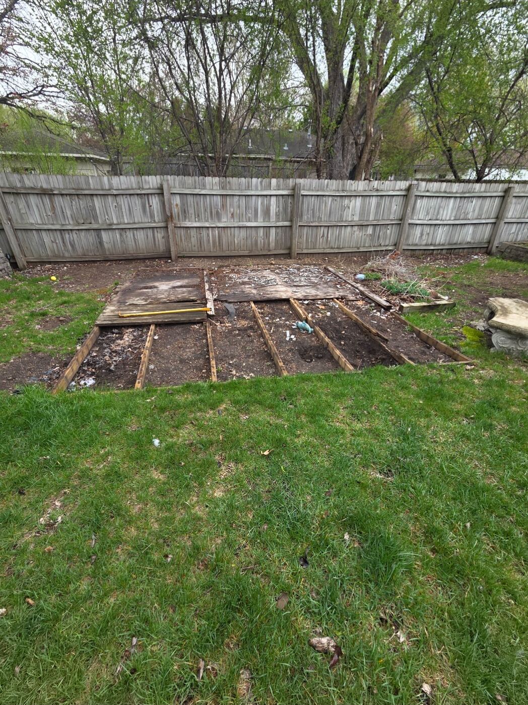 Before: rotted deck torn down to joists in a backyard