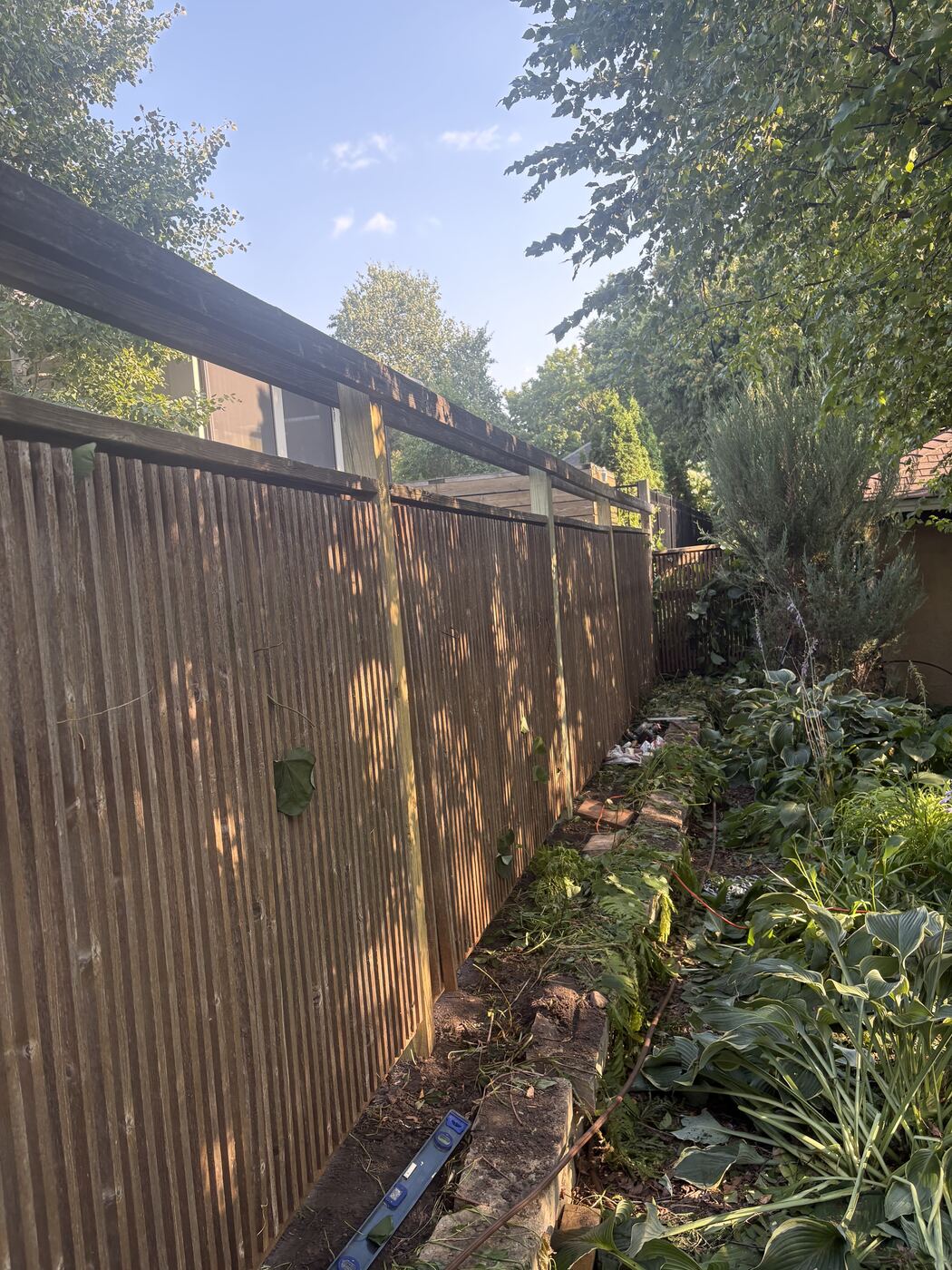 After: the fence pulled back to plumb with new posts set along the line