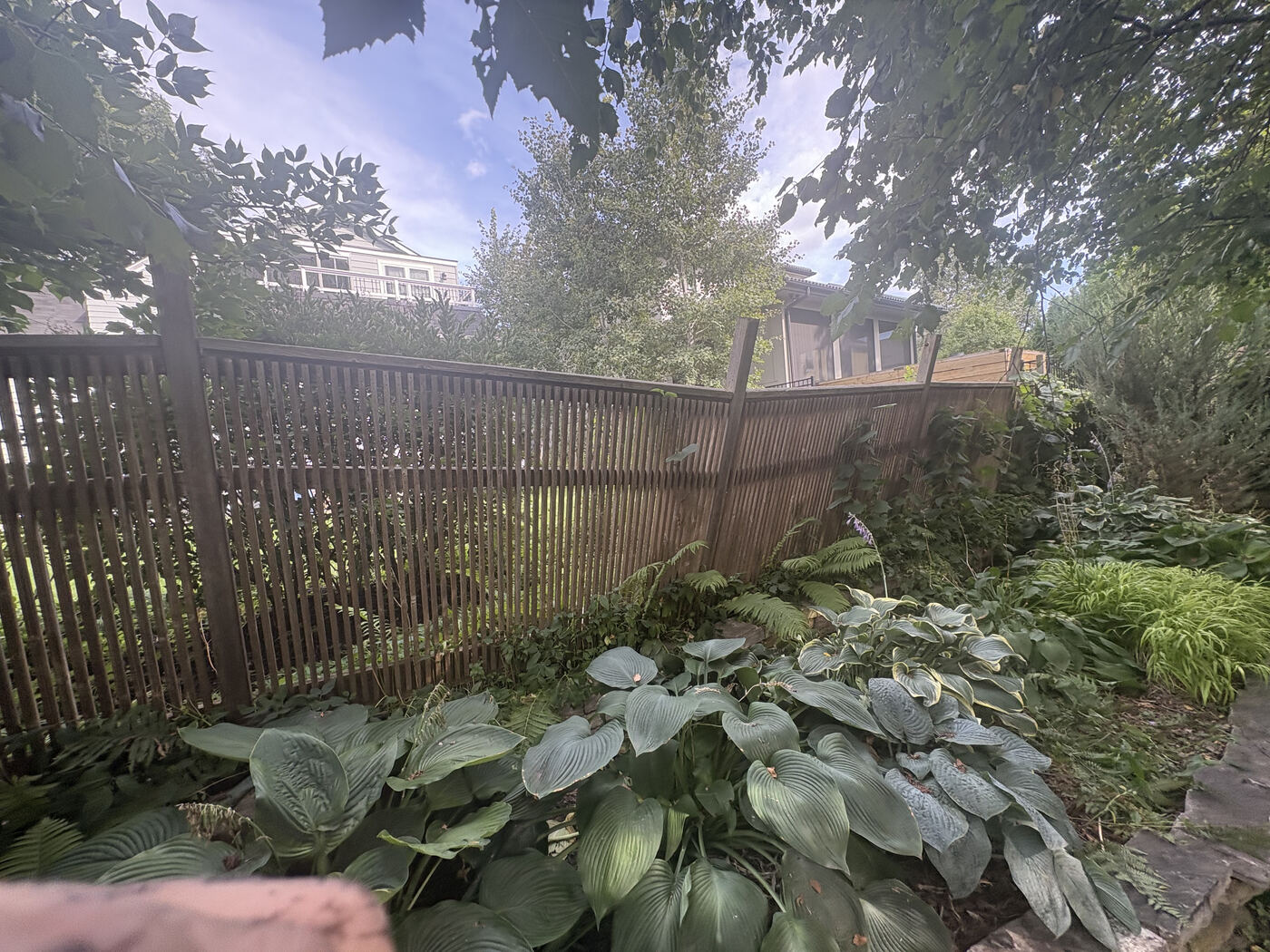 Before: wooden slat fence leaning badly out of plumb