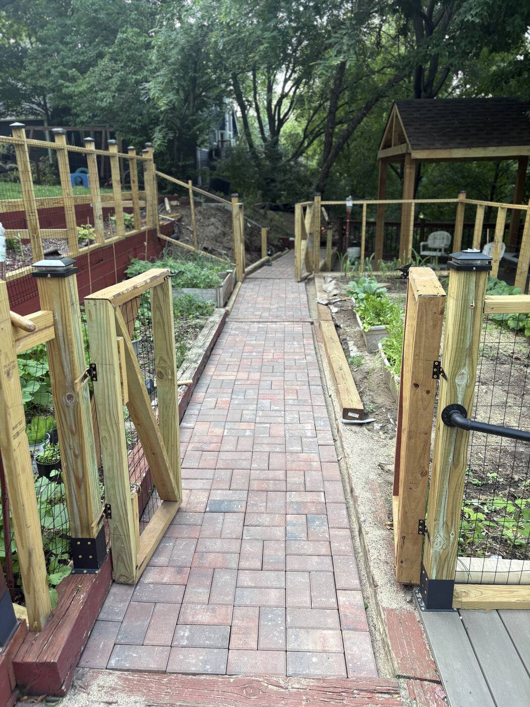 After: finished brick paver walkway with new garden fencing and gates