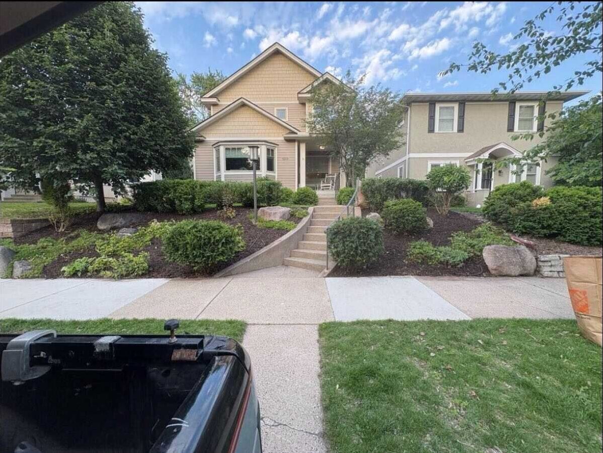 Fully landscaped front yard with mulched beds, boulders, and shrubs