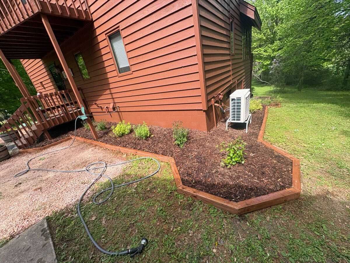 New mulch beds and edging installed around a cabin