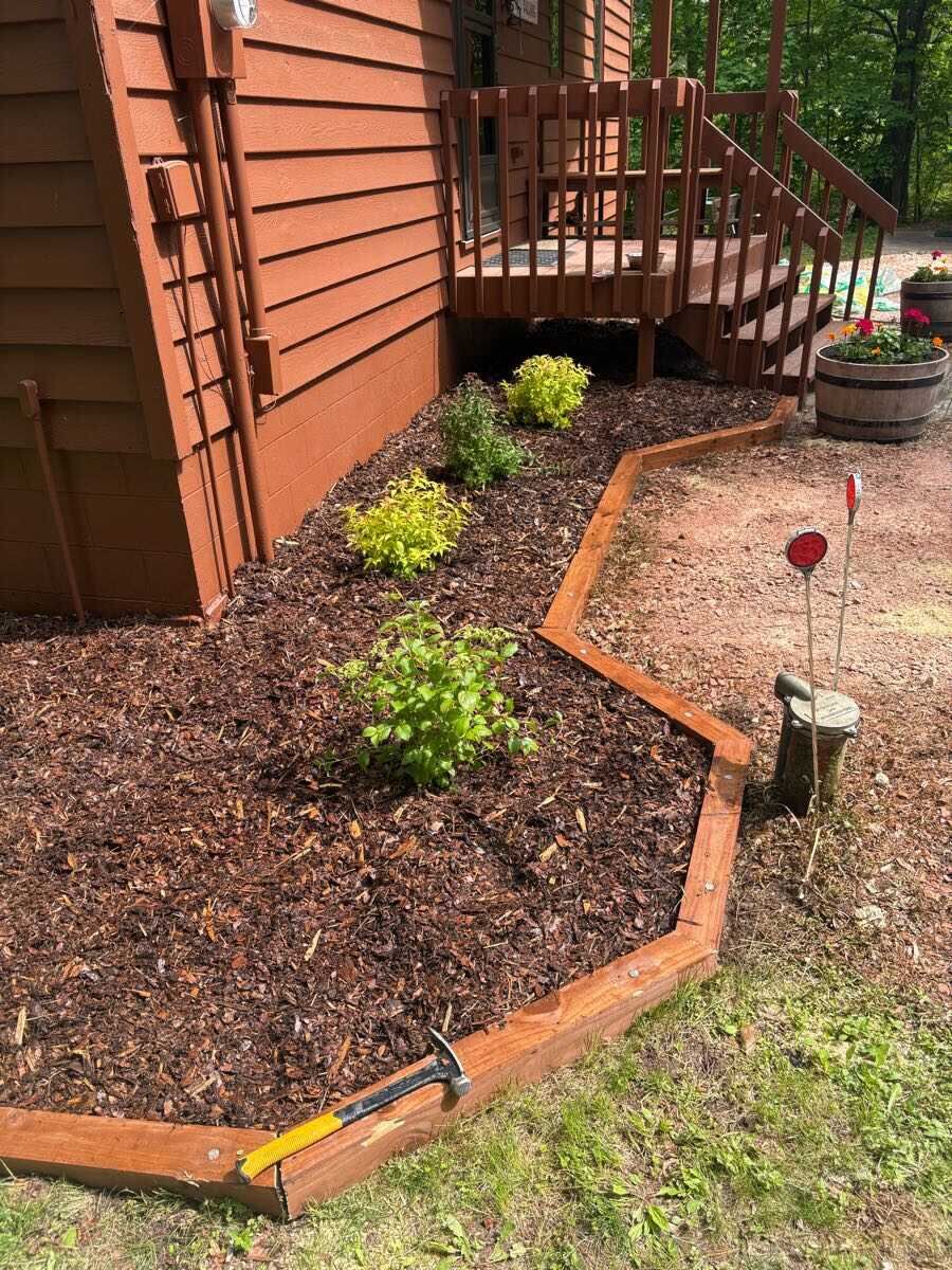 Fresh mulch bed with new wooden edging and plantings