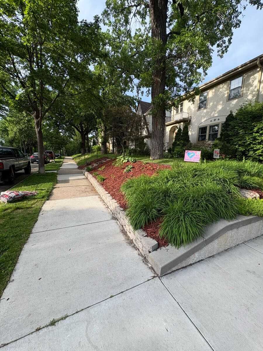 Retaining wall planting with ornamental grasses and fresh mulch